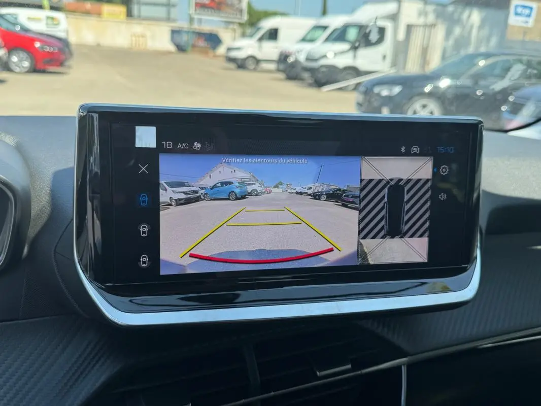 Écran tactile intérieur de la Peugeot 208 Hybrid gris, affichant la caméra de recul avec vue arrière et vue 360° en stationnement.