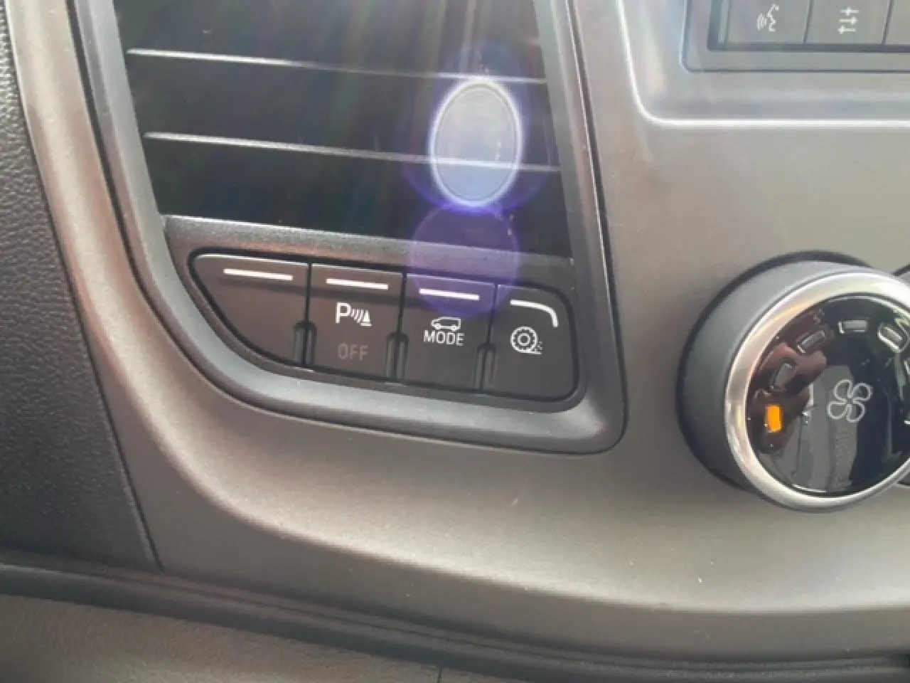 Gros plan sur les commandes de l'aide au stationnement et mode de conduite du Ford Transit Fourgon blanc 2023.