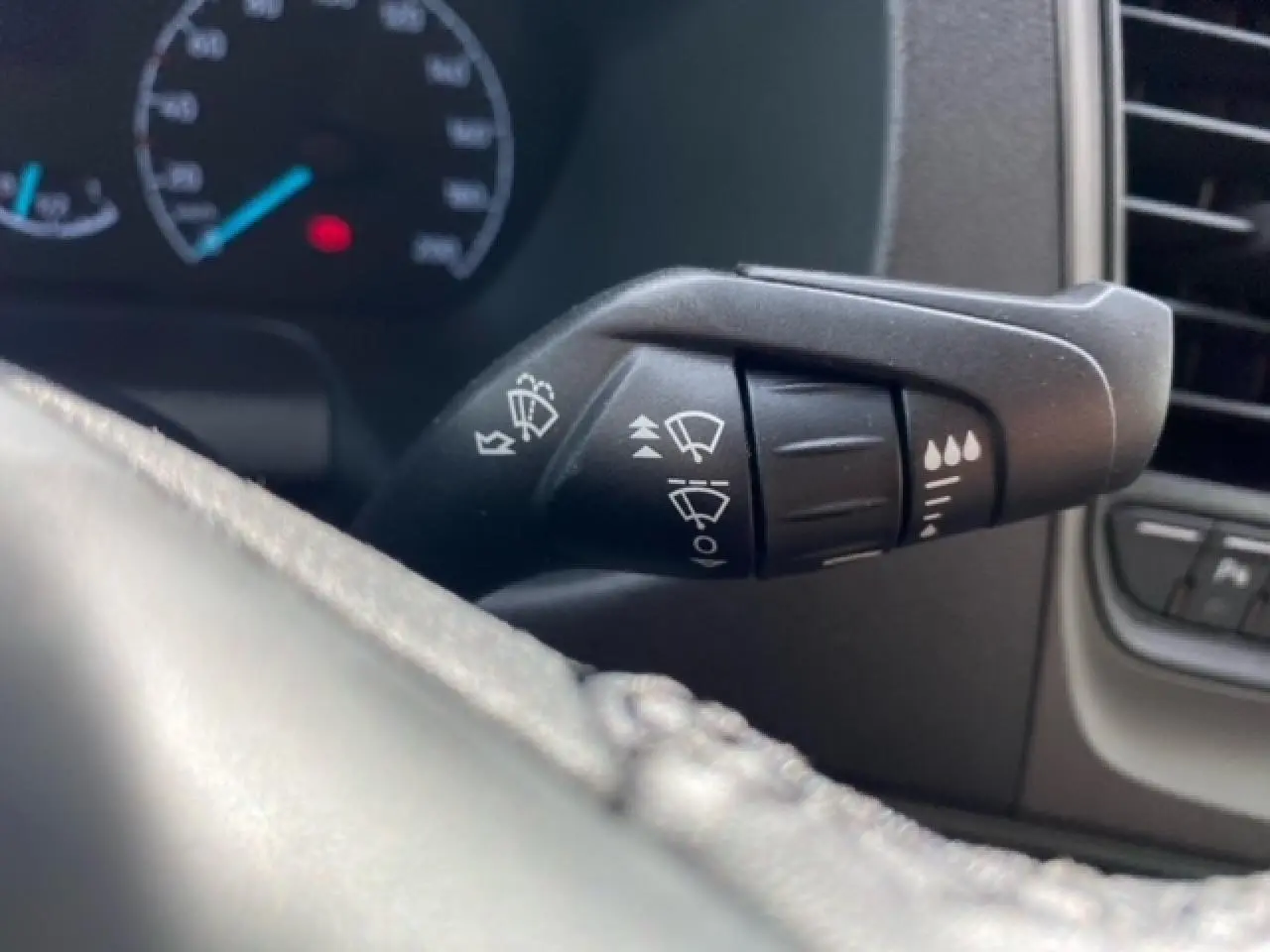 Gros plan sur la commande des essuie-glaces du Ford Transit Fourgon blanc 2023, intérieur tableau de bord.