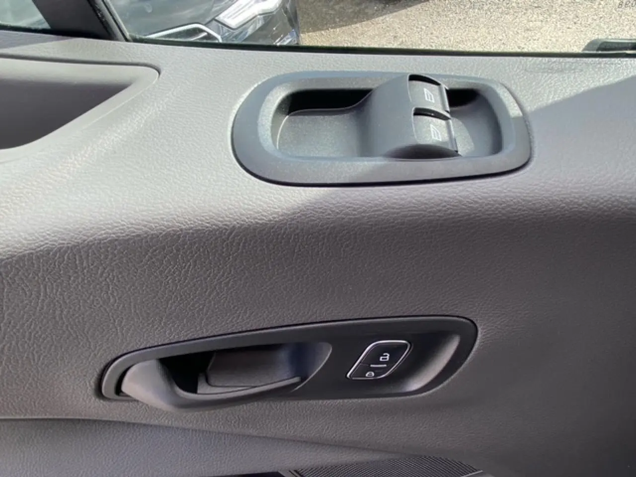 Gros plan sur la porte intérieure côté conducteur du Ford Transit Fourgon blanc, avec commandes de vitres et verrouillage.