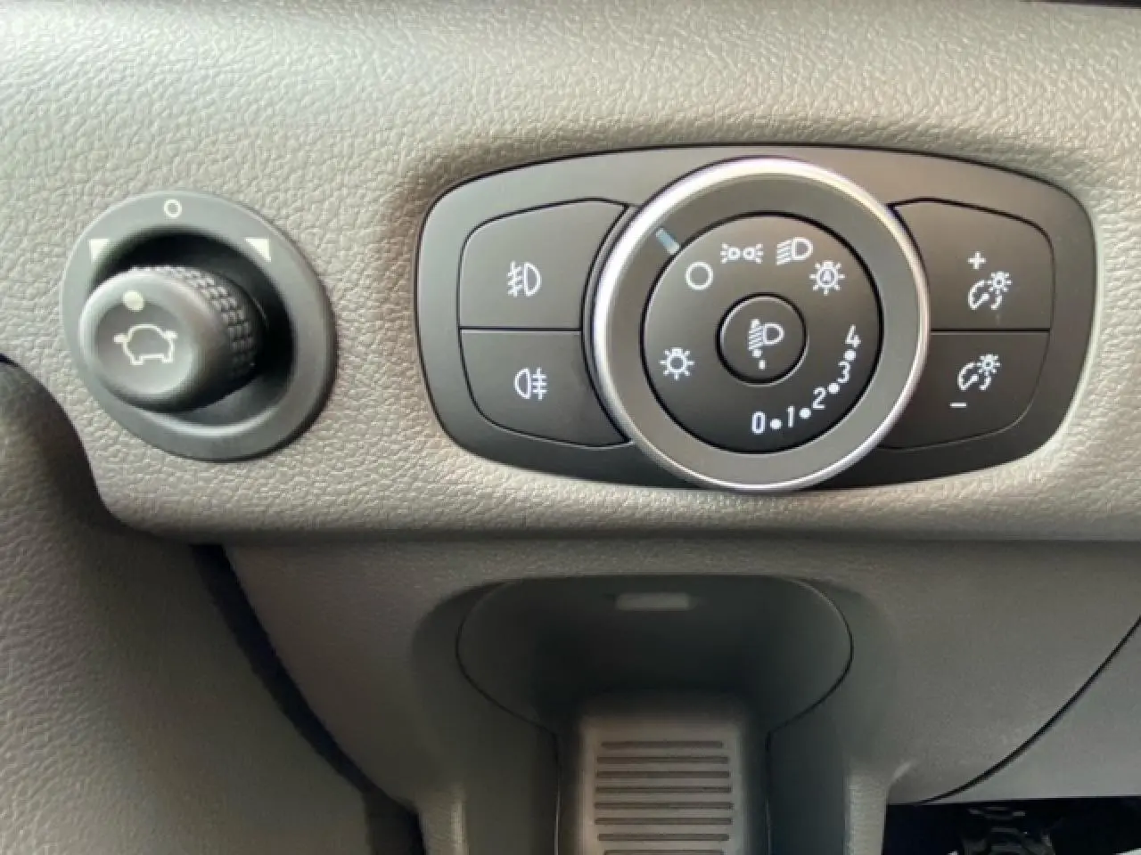 Gros plan sur les commandes d'éclairage et réglage du tableau de bord du Ford Transit Fourgon blanc 2023.