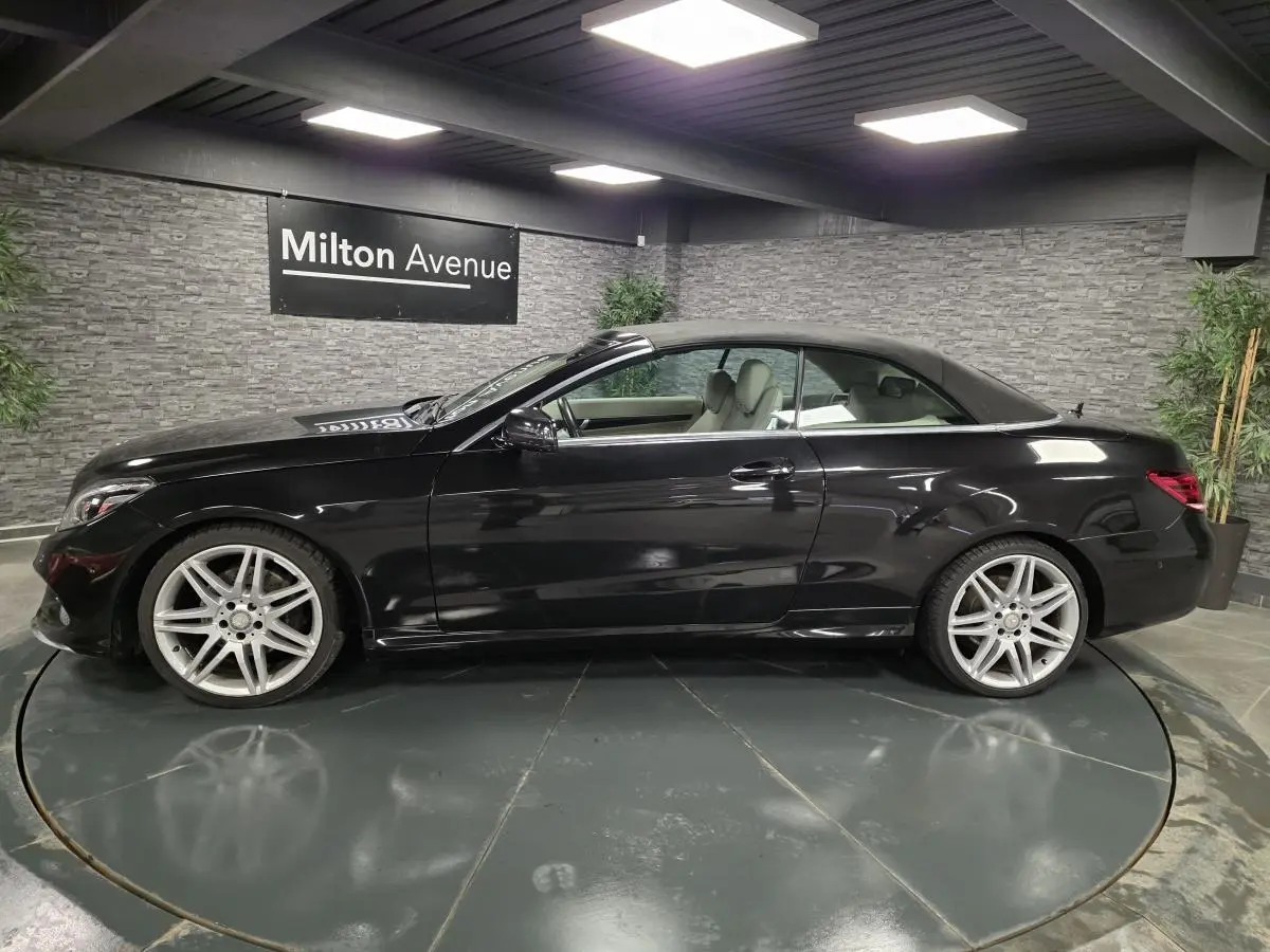 Profil côté gauche d'un cabriolet Mercedes Classe E noir avec jantes alliage 19 pouces dans un showroom.