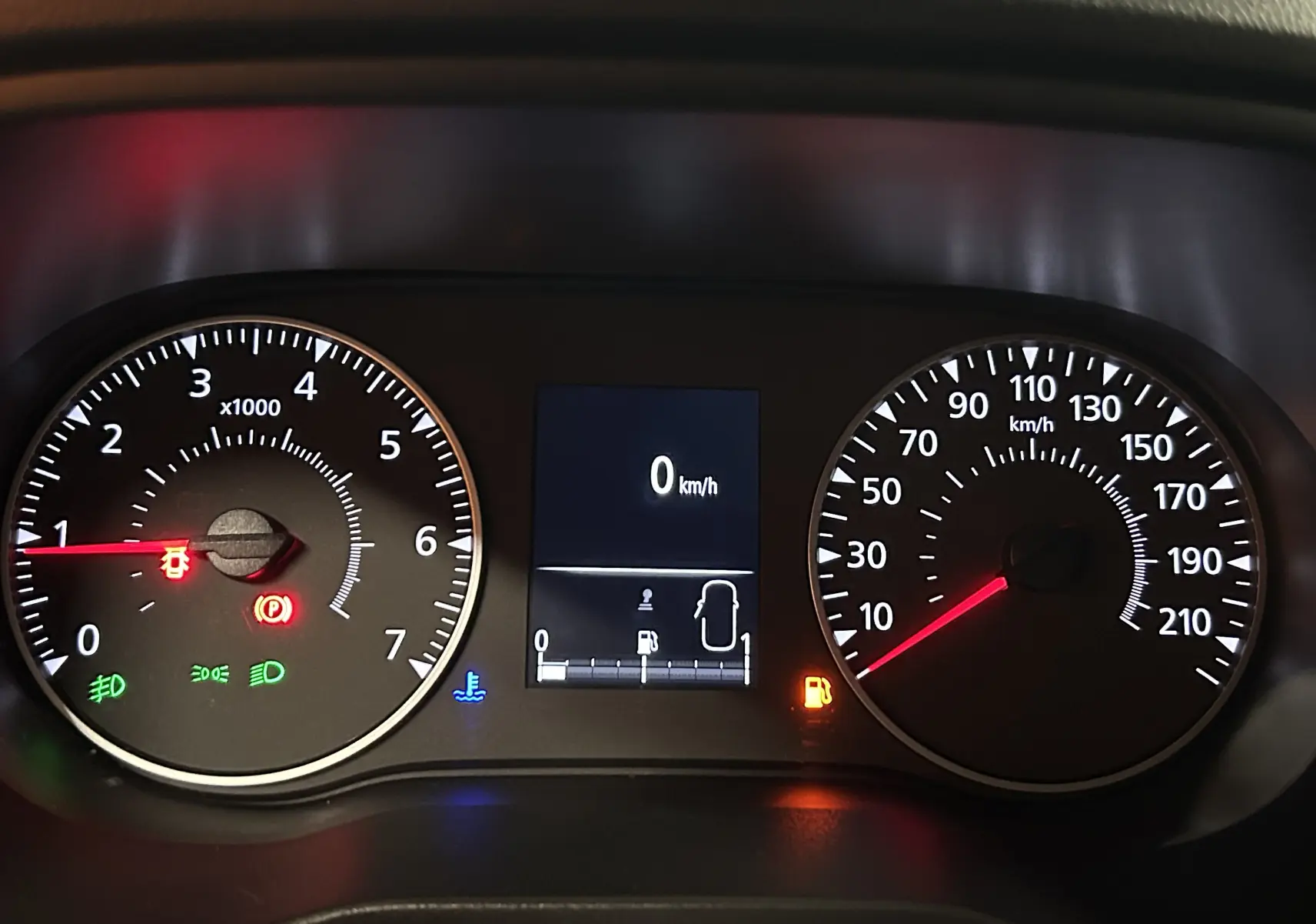 Vue rapprochée du tableau de bord du Dacia Duster blanc 2024, affichant le compteur de vitesse et les voyants allumés.