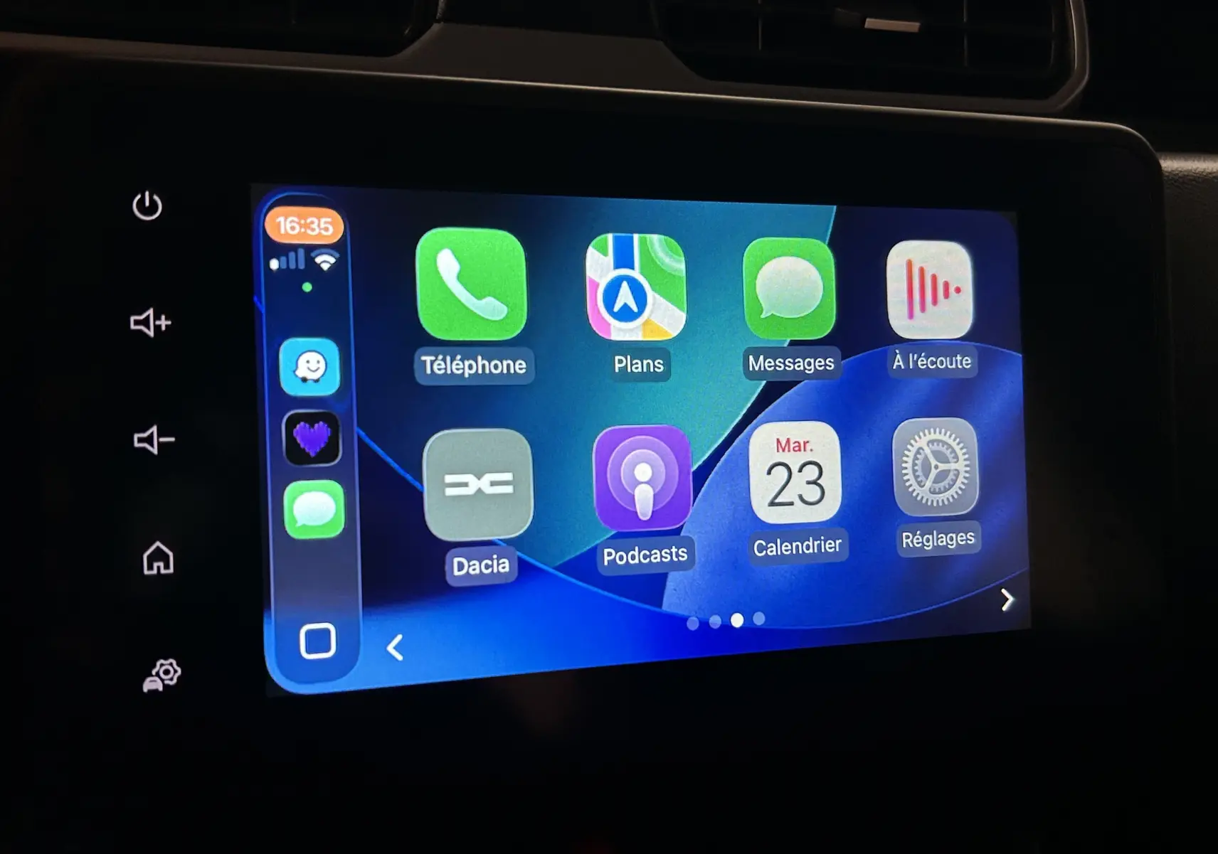Écran tactile central du Dacia Duster 2024 affichant l'interface Apple CarPlay avec plusieurs applications visibles.