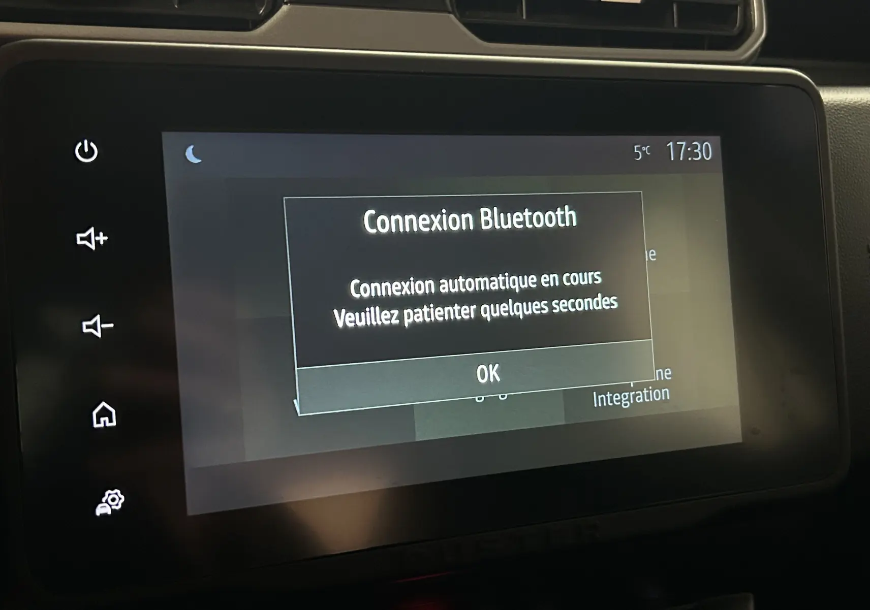 Écran tactile central du Dacia Duster 2024 affichant une connexion Bluetooth en cours, avec boutons tactiles latéraux visibles.