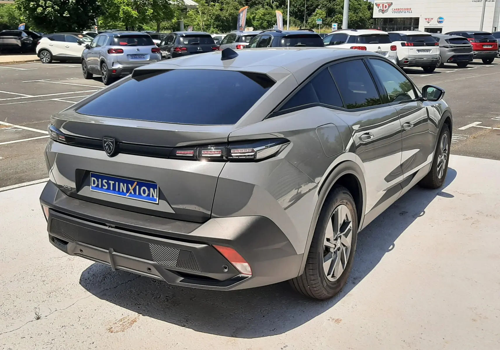 Vue 3/4 arrière droite d'une Peugeot 408 Hybrid gris selenium avec feux arrière LED et vitrage arrière teinté.