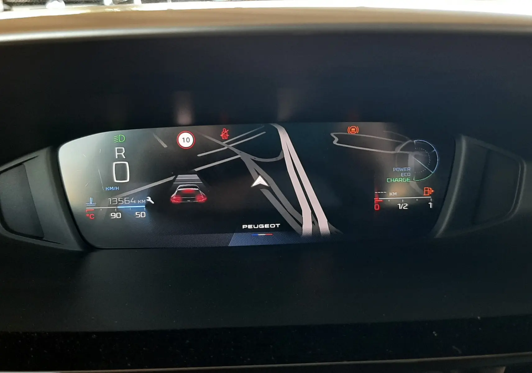 Vue intérieure du tableau de bord numérique du Peugeot 408 Hybrid 2024, affichant la navigation et les indicateurs de conduite.