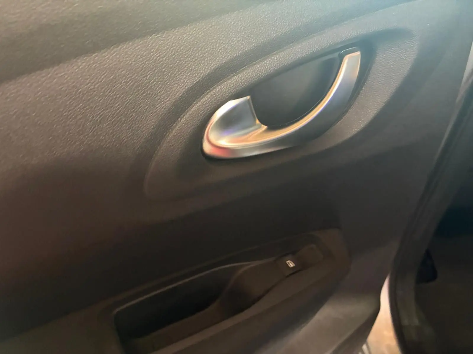 Poignée intérieure argentée et commande de lève-vitre sur la portière côté gauche du Renault Kadjar gris 2020.
