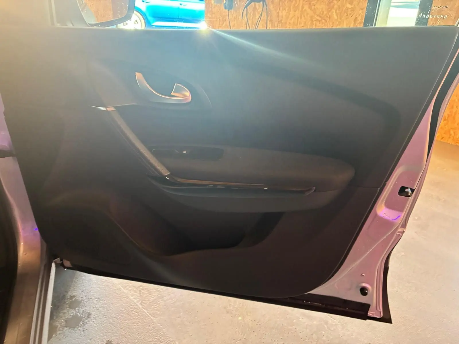 Vue intérieure de la porte avant gauche du Renault Kadjar gris, avec poignée argentée et garniture noire.