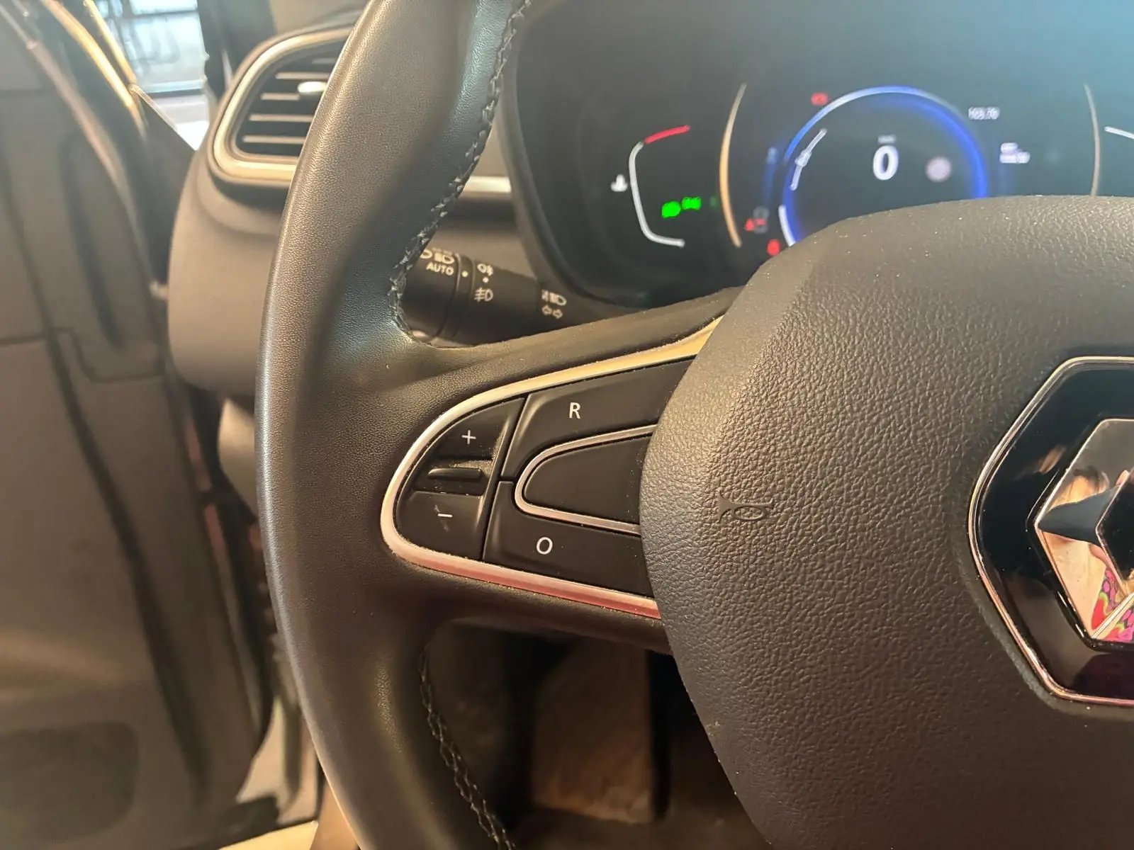 Gros plan sur le volant noir de Renault Kadjar 2020 avec commandes intégrées et tableau de bord numérique en arrière-plan.
