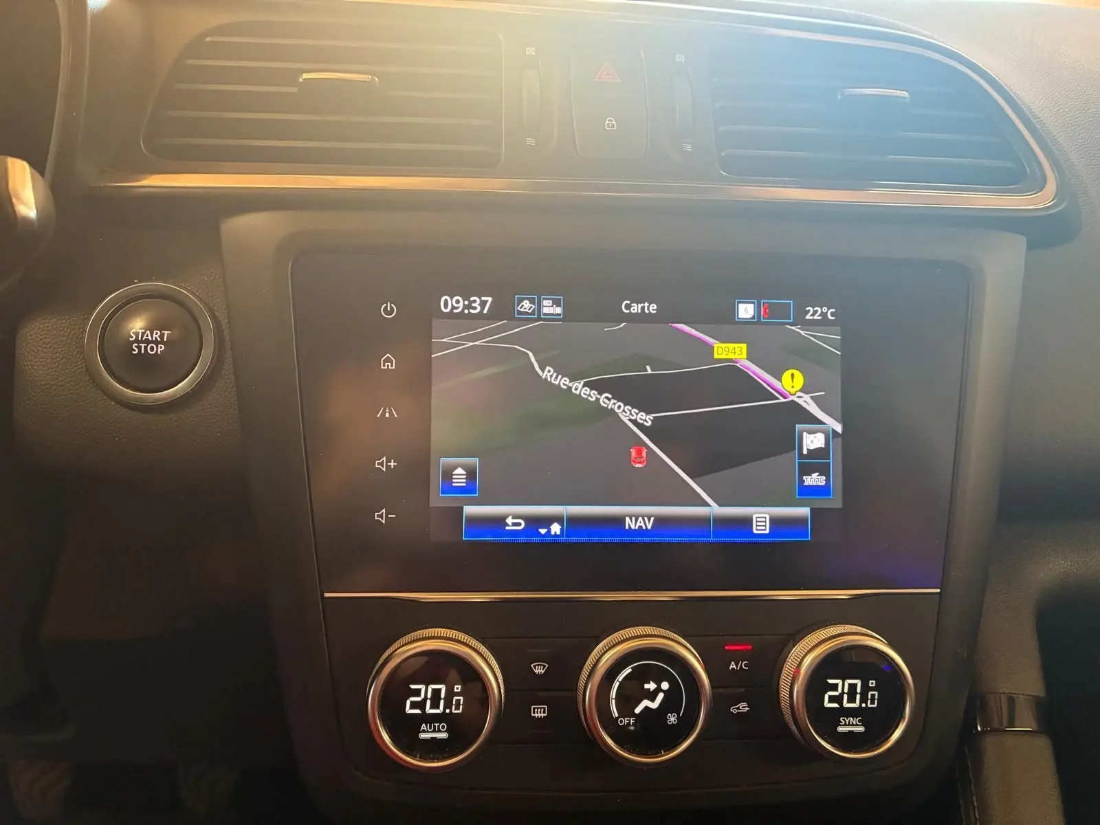 Vue rapprochée du tableau de bord du Renault Kadjar 2020 gris, avec écran GPS et commandes de climatisation digitales.