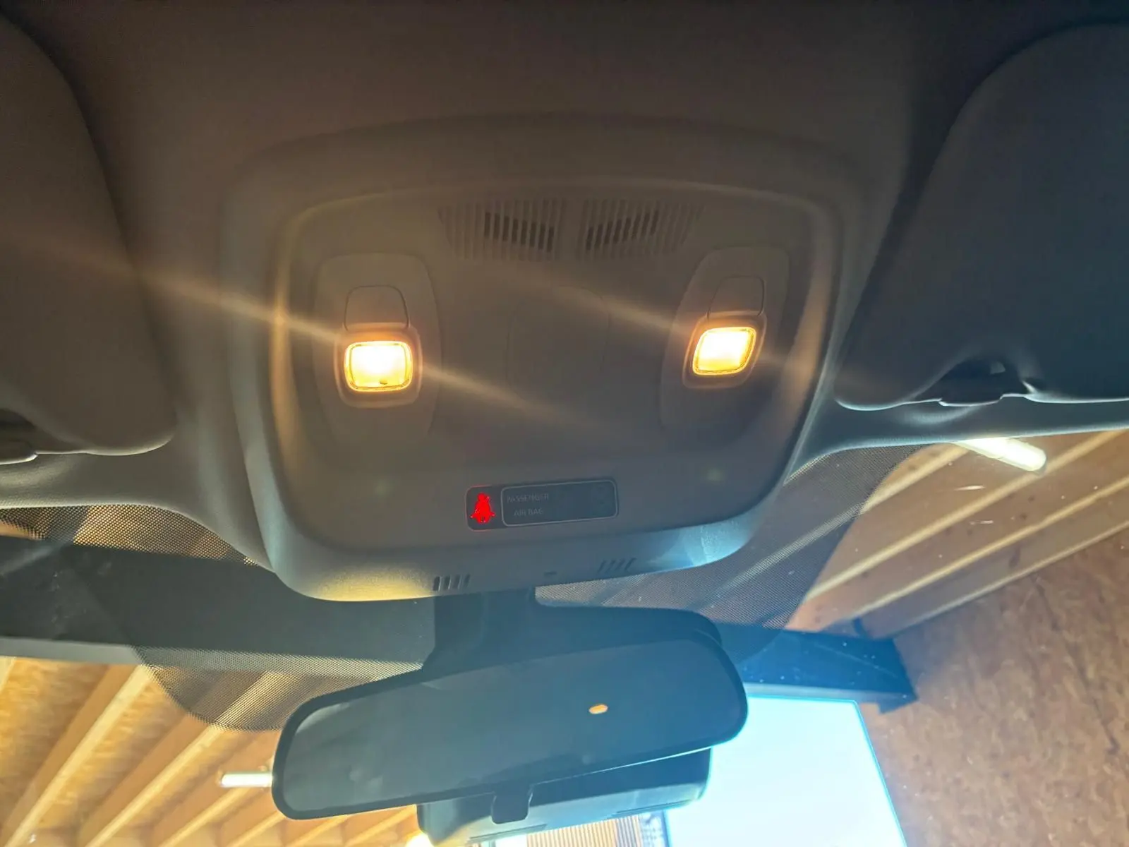Vue intérieure en contre-plongée du plafonnier avec éclairage allumé et rétroviseur d’un Renault Kadjar gris 2020.