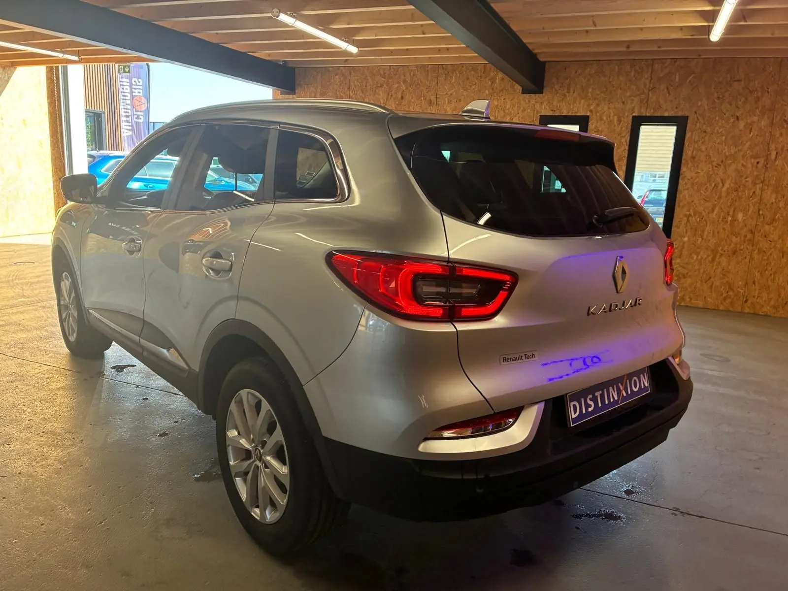 Vue 3/4 arrière droite d’un Renault Kadjar gris 2020 avec feux arrière LED et logo distinctif Renault.