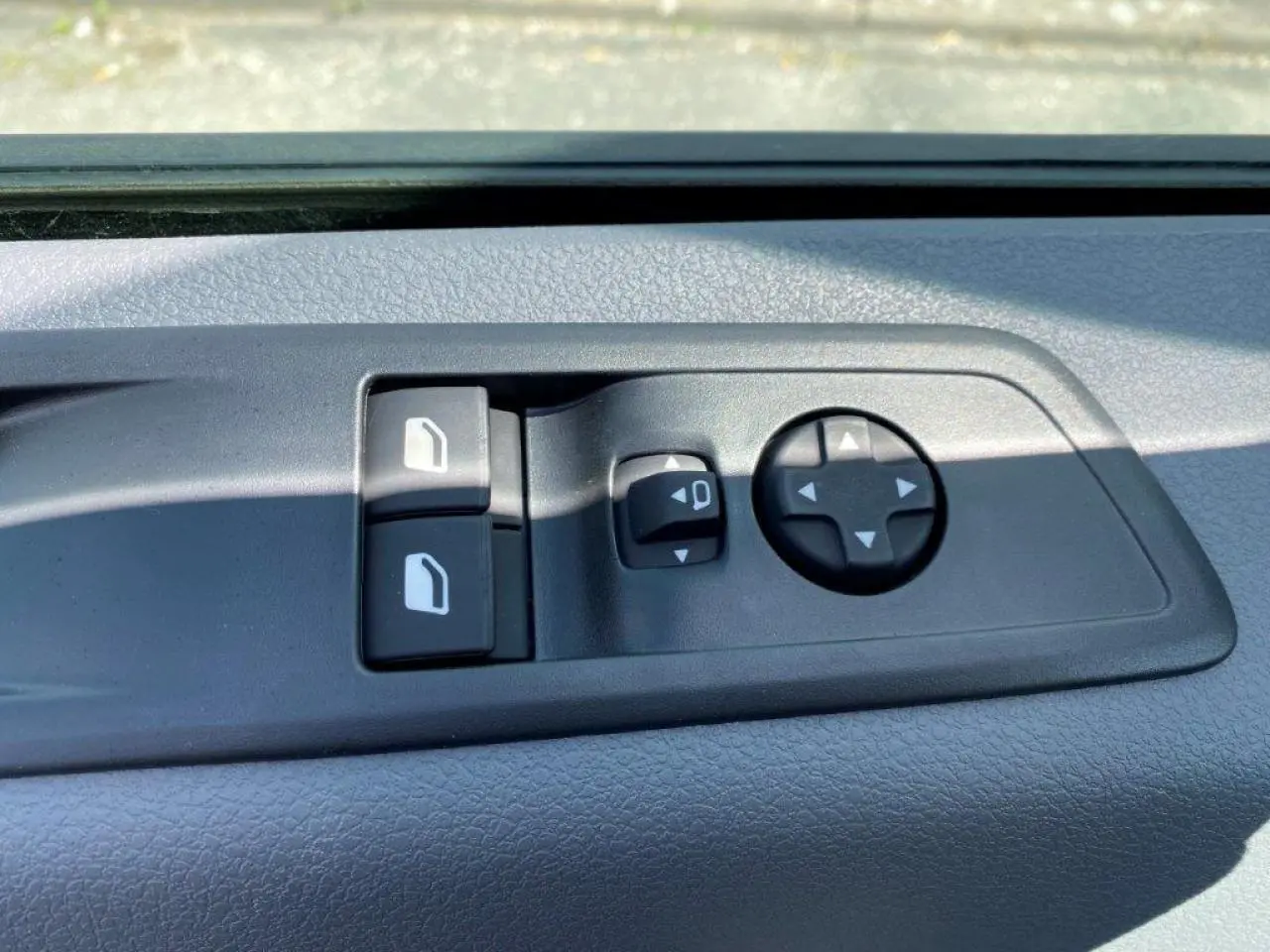 Gros plan sur les commandes de réglage des rétroviseurs et des vitres côté conducteur du Peugeot Expert Fourgon blanc 2023.
