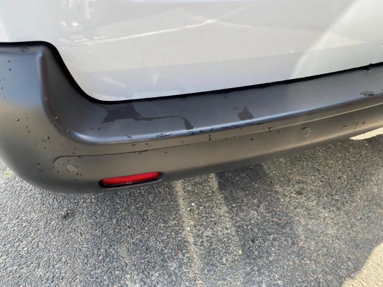 Gros plan sur le pare-chocs arrière noir et la carrosserie blanche du Peugeot Expert Fourgon 2023.