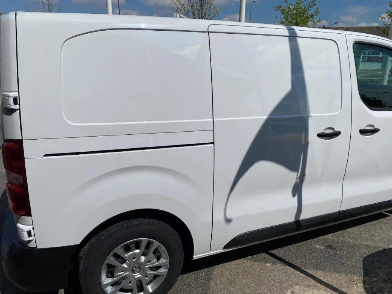 Vue latérale droite d'un Peugeot Expert Fourgon blanc 2023 avec porte coulissante et jante acier.