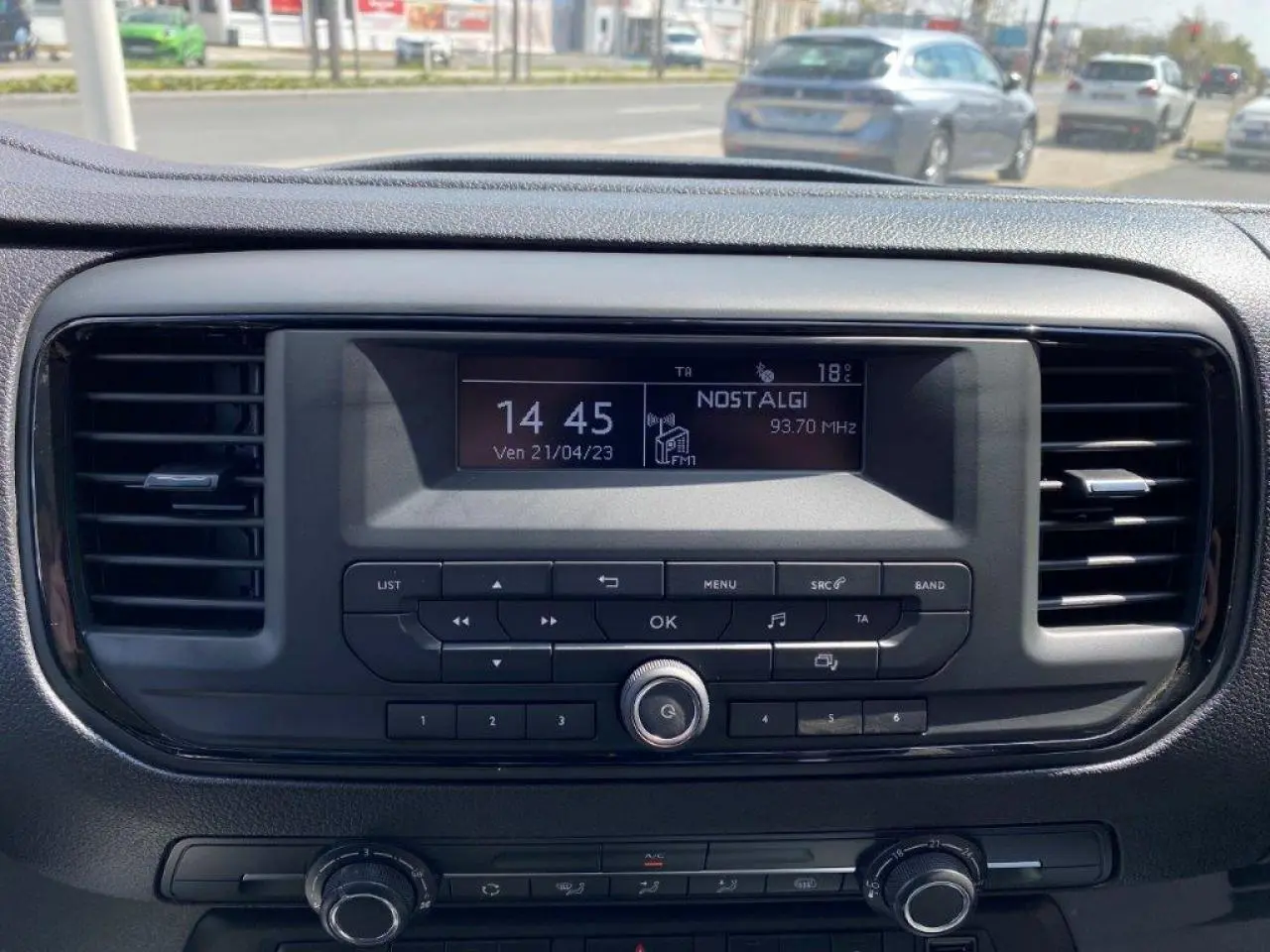 Tableau de bord du Peugeot Expert Fourgon blanc 2023, vue frontale centrée sur l'autoradio et les commandes climatiques.