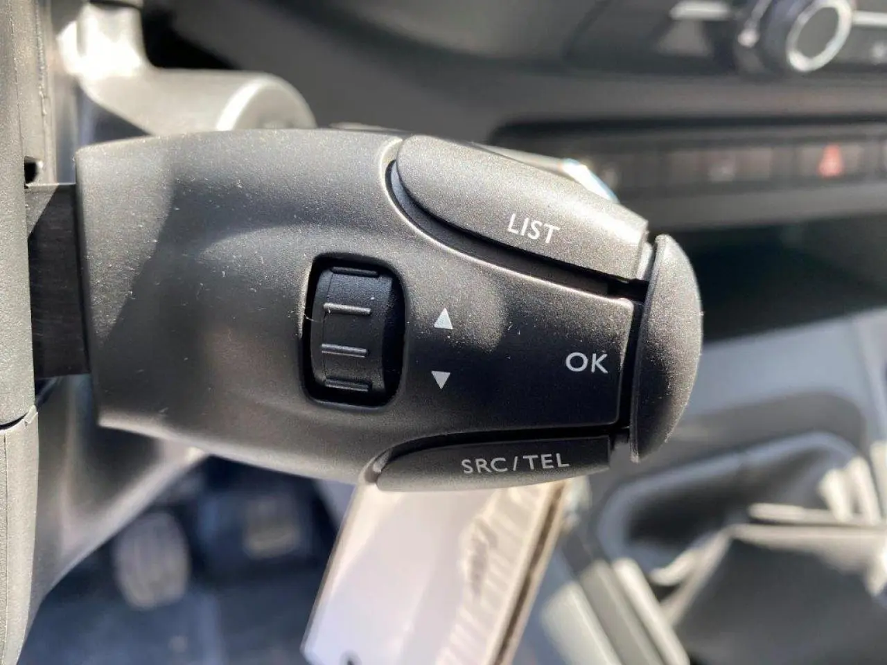 Gros plan sur la commande au volant du Peugeot Expert Fourgon blanc 2023, boutons LIST, OK et SRC/TEL visibles.