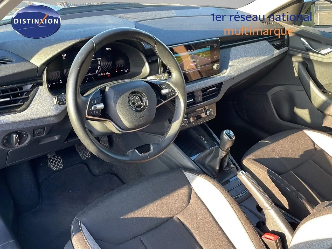 Intérieur avant du Skoda Kamiq 2024 noir magique métal, volant multifonction et levier de vitesse manuel visible de côté gauche.