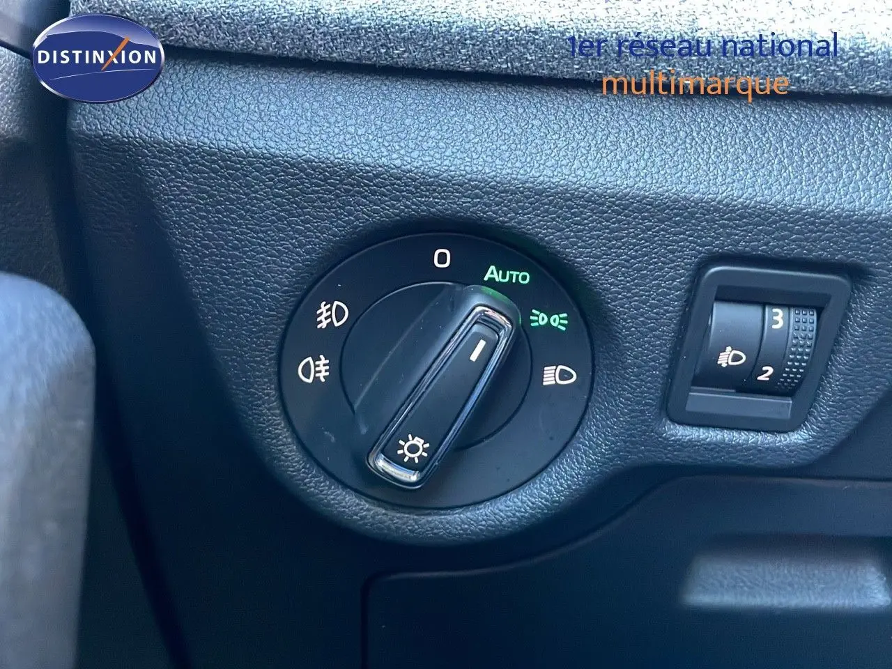 Gros plan sur le sélecteur de phares noir et la molette de réglage d'intensité lumineuse dans une Skoda Kamiq noire.