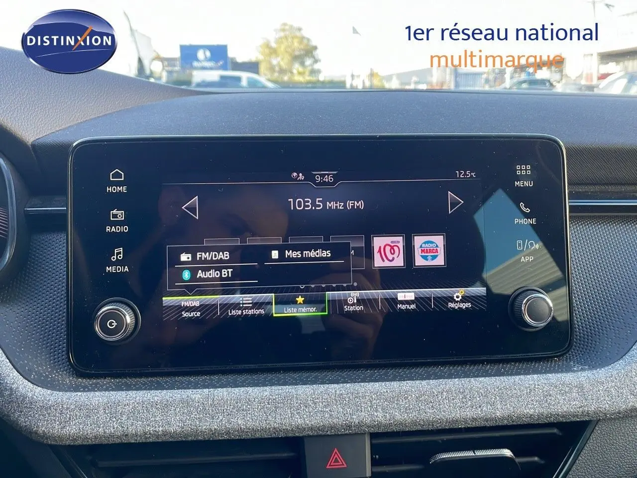 Écran tactile central du tableau de bord du Skoda Kamiq noir magique métal 2024, affichant la radio FM à 103.5 MHz.