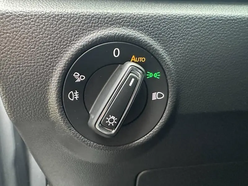 Gros plan sur le sélecteur d'éclairage intérieur du Volkswagen T-Roc gris 2025, montrant la position automatique activée.