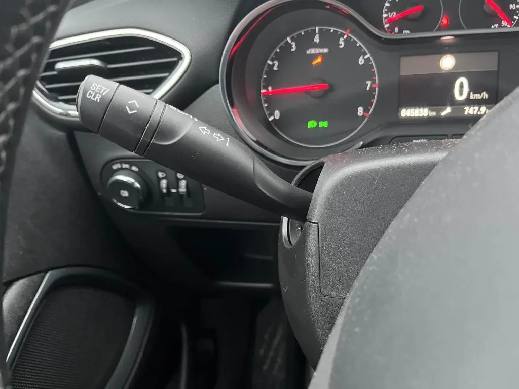 Gros plan sur la manette de clignotant à gauche du volant dans l'habitacle noir de l'Opel Crossland 2021.