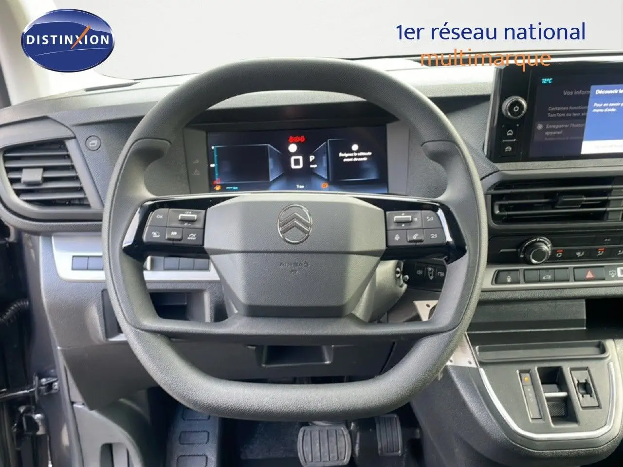Vue intérieure centrée sur le volant multifonction du Citroën Jumpy 2025, tableau de bord numérique et console gris titane.