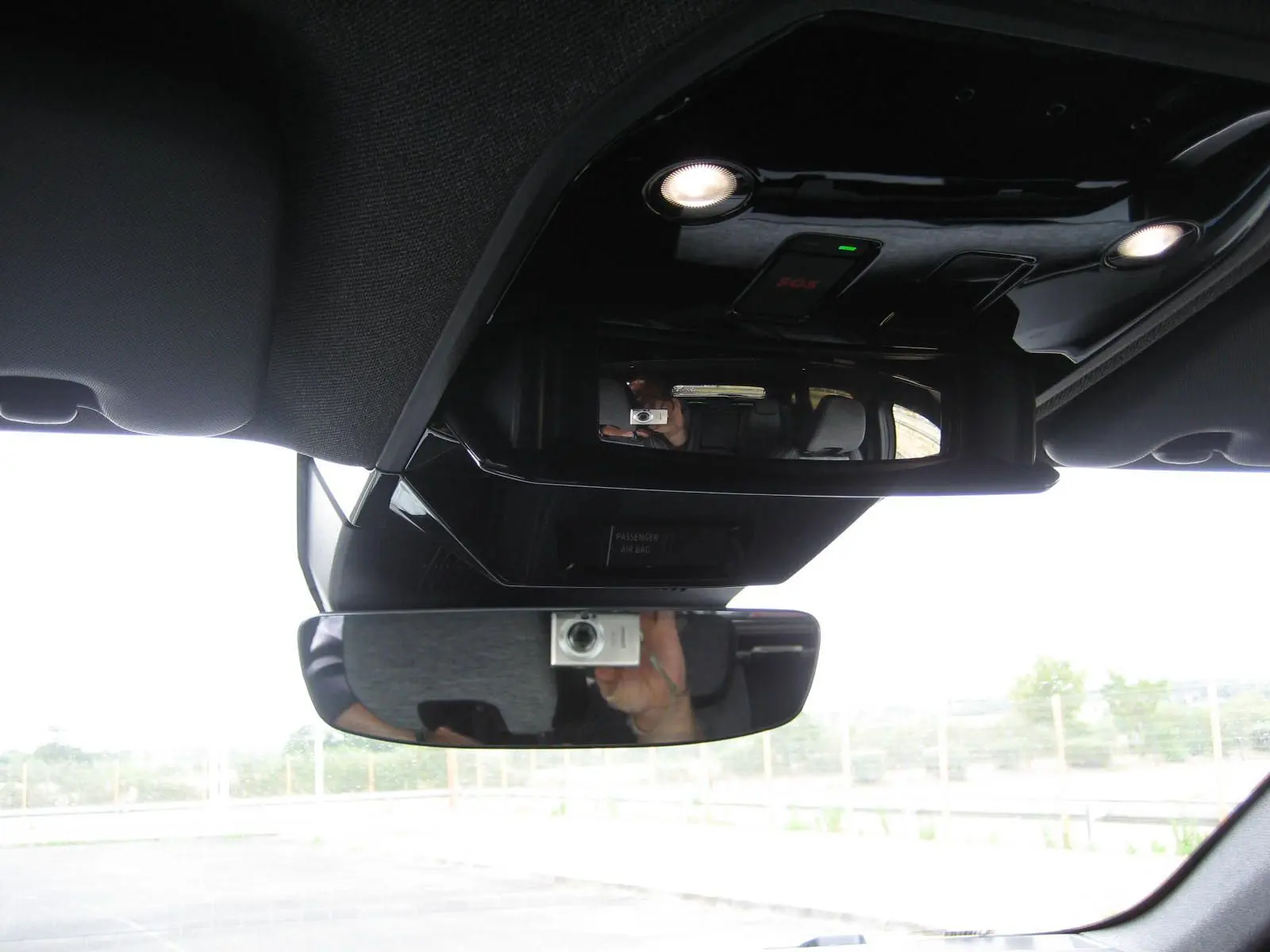 Vue intérieure centrée sur le rétroviseur et la console de plafond du Renault Austral gris, avec éclairage LED intégré.