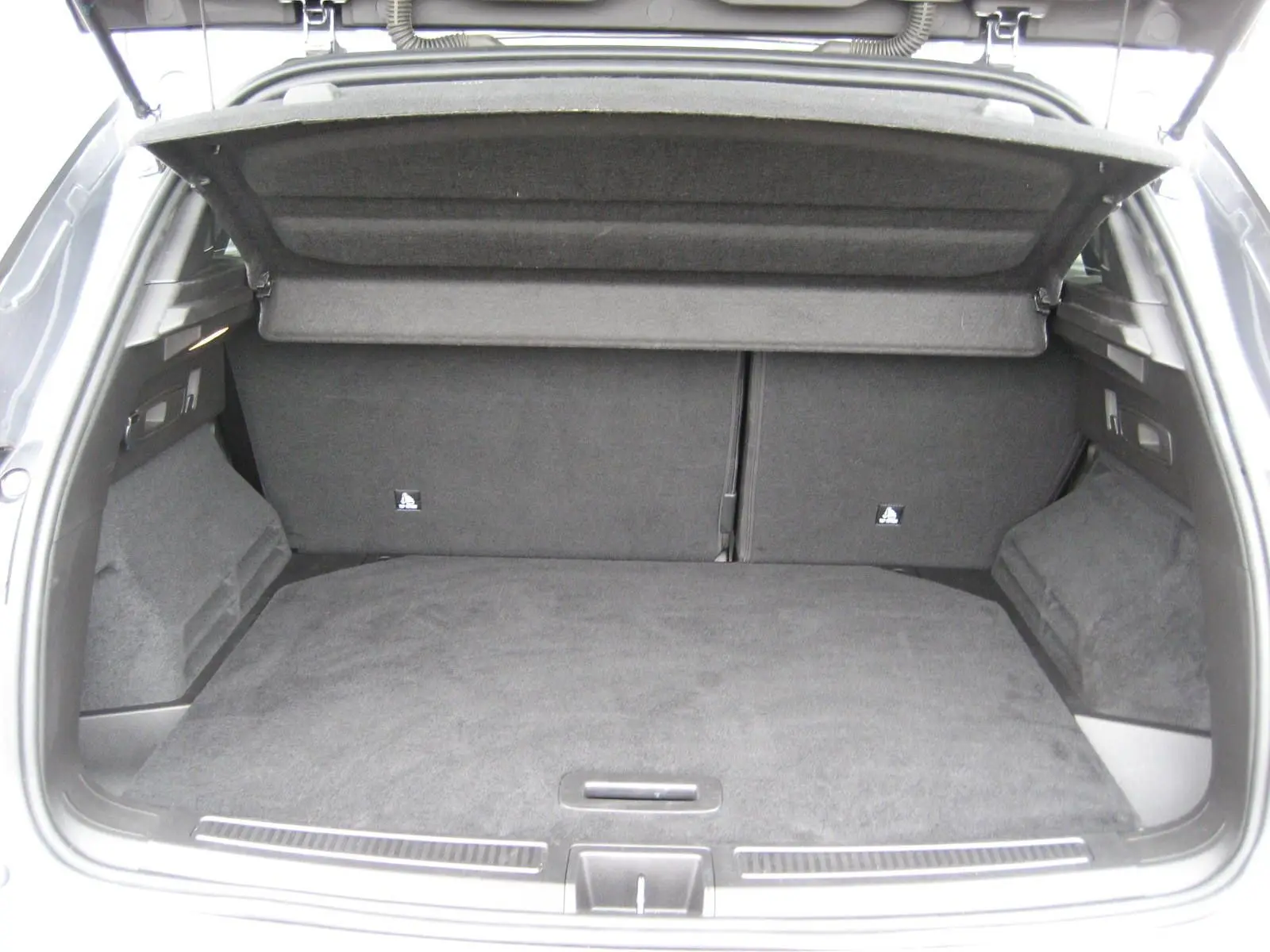 Coffre ouvert d’un Renault Austral gris, vue arrière montrant un espace de chargement spacieux et bien fini.