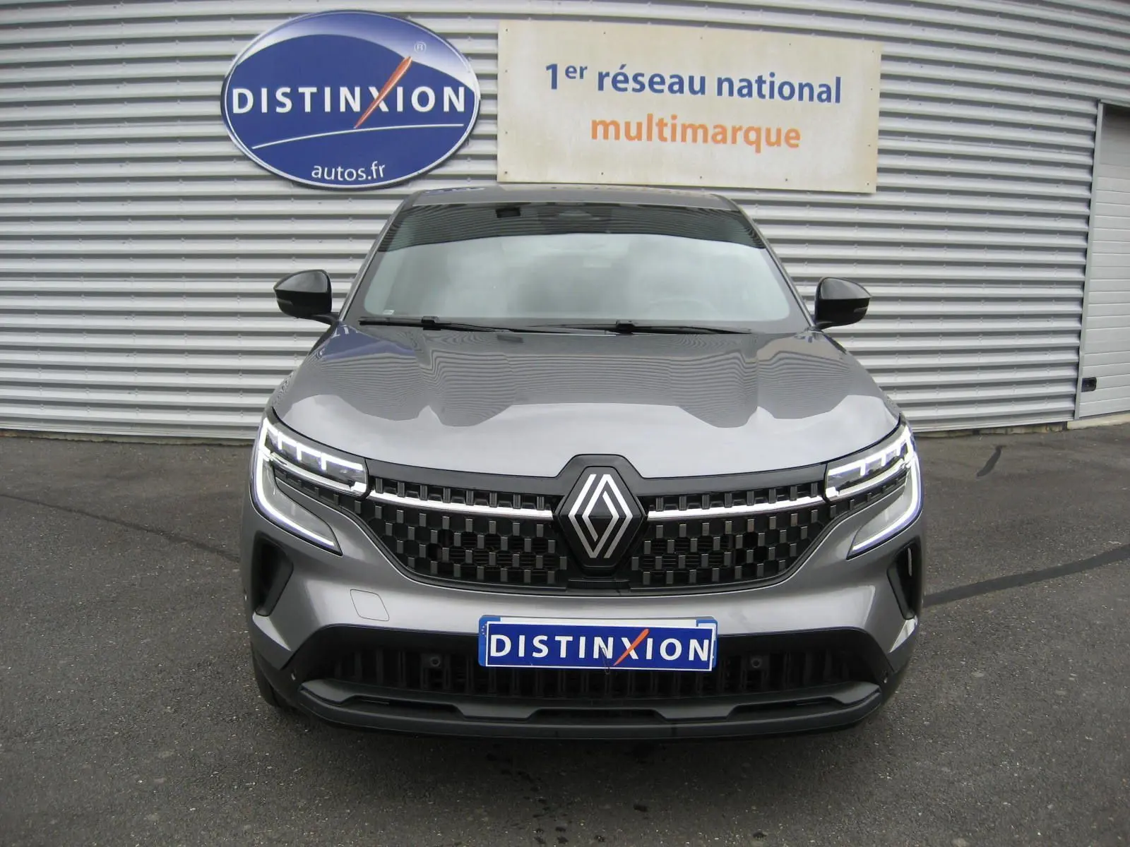 Vue avant d'un Renault Austral gris 2025 avec calandre noire à damier et phares LED distinctifs.