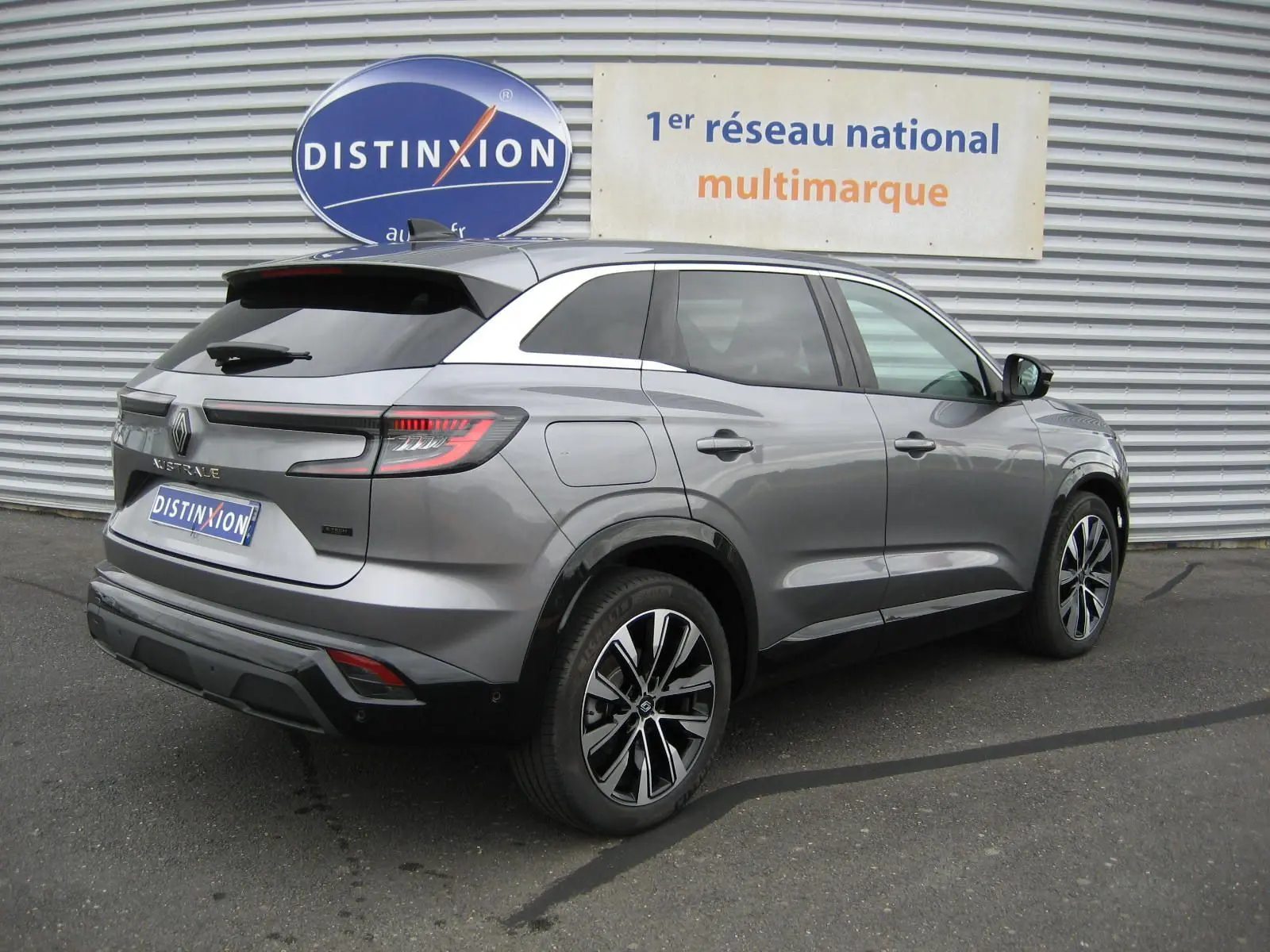Vue 3/4 arrière droite d'un Renault Austral gris 2025, avec jantes bi-ton et feux arrière LED distinctifs.