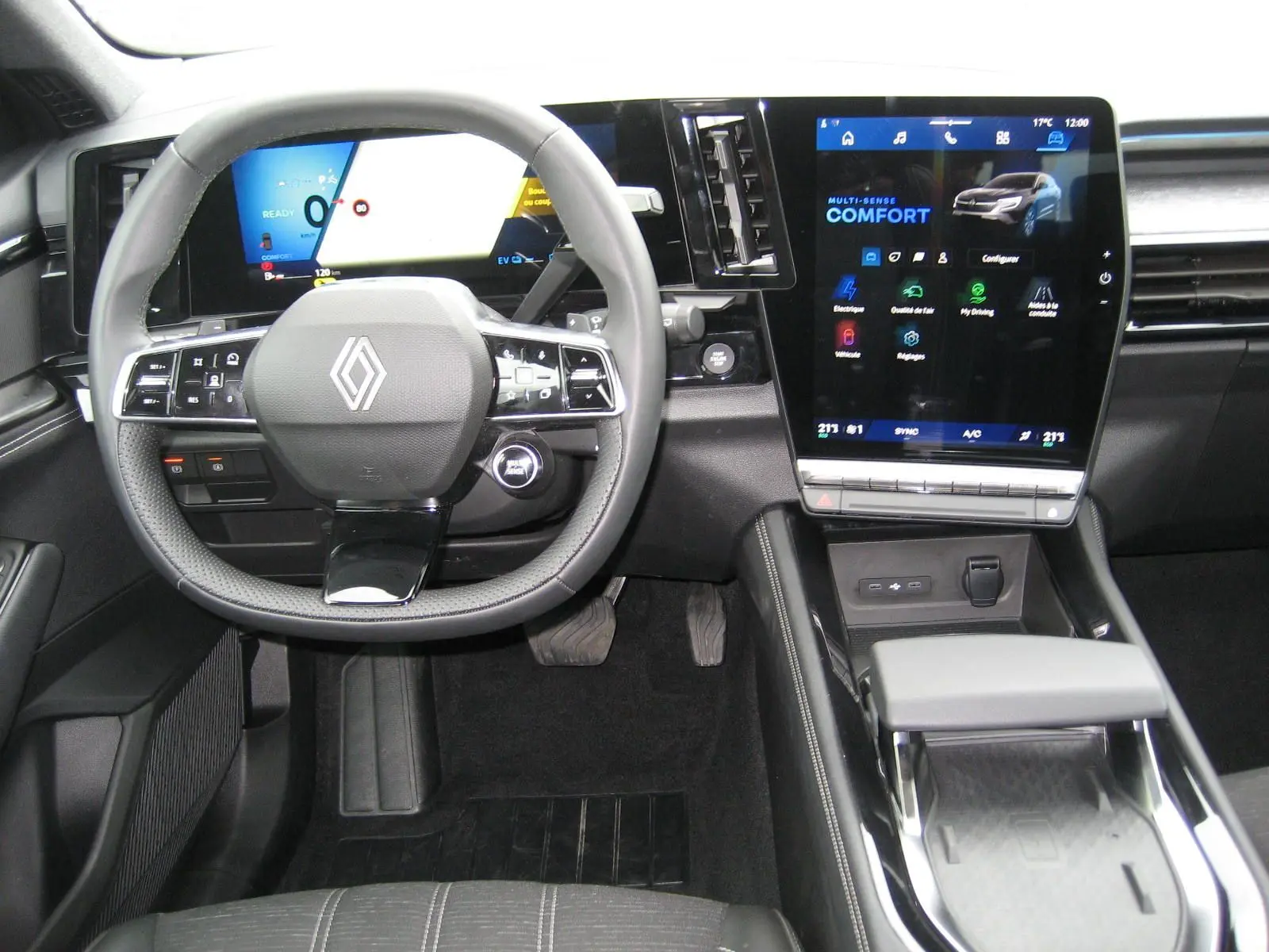 Vue intérieure du poste de conduite du Renault Austral gris, avec volant multifonction et écran tactile central vertical.