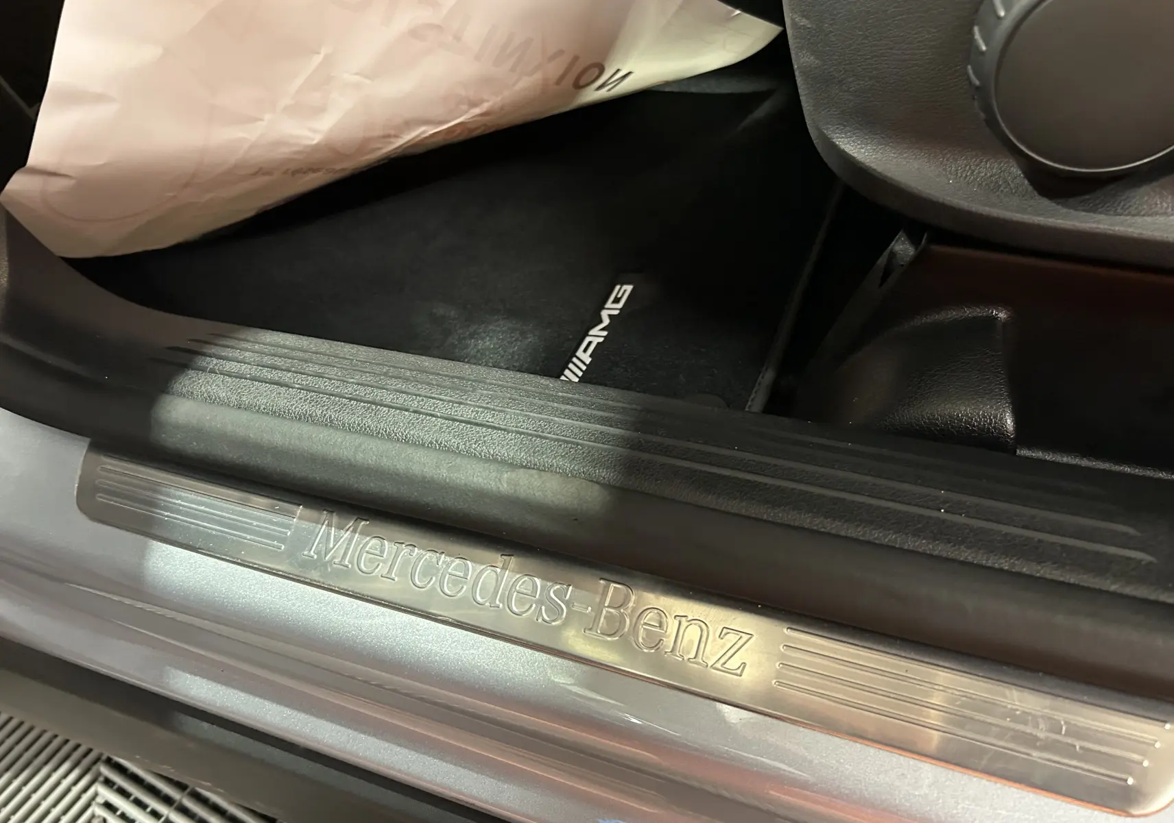 Gros plan sur la baguette de seuil de porte argentée Mercedes-Benz et tapis AMG noir dans un GLA 200 D AMG Line 2024.