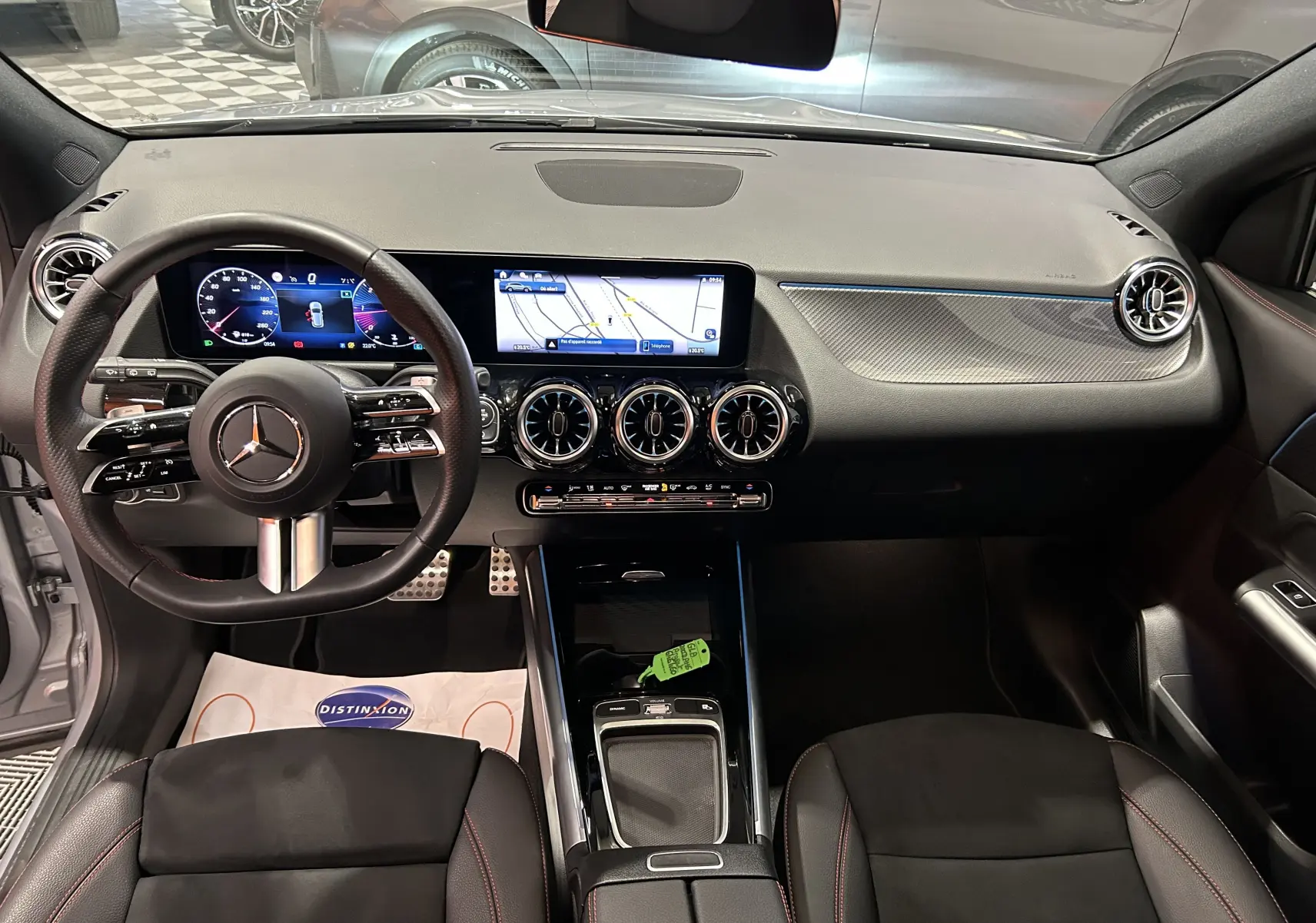 Vue intérieure avant du tableau de bord et volant noir du Mercedes GLA 200 D AMG Line 2024 avec écran digital et aérateurs ronds.