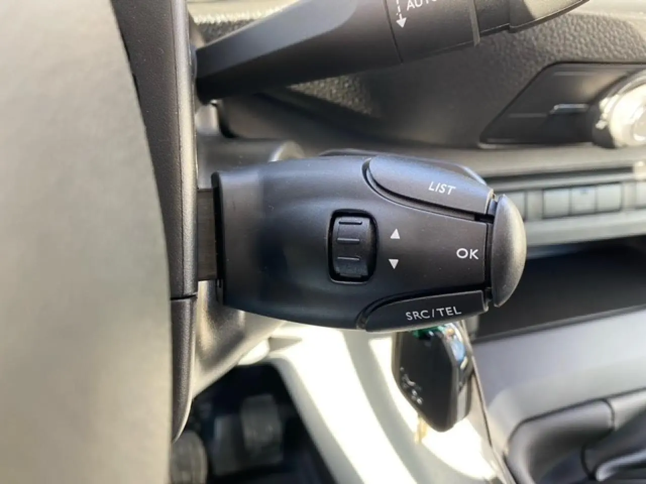 Gros plan sur la commande au volant noir du Peugeot Expert Fourgon blanc banquise, avec clé insérée dans le contact.