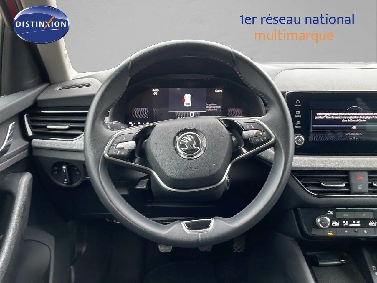 Vue frontale du poste de conduite du Skoda Kamiq 2024, volant multifonction et tableau de bord numérique visibles.