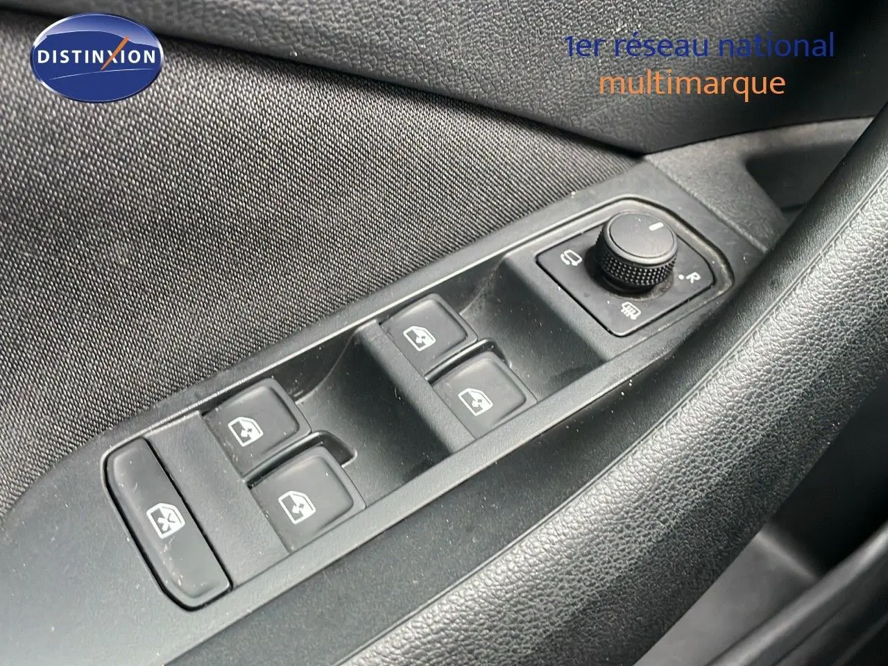 Gros plan sur les commandes de lève-vitres et réglage des rétroviseurs côté conducteur d'une Skoda Kamiq 2024.