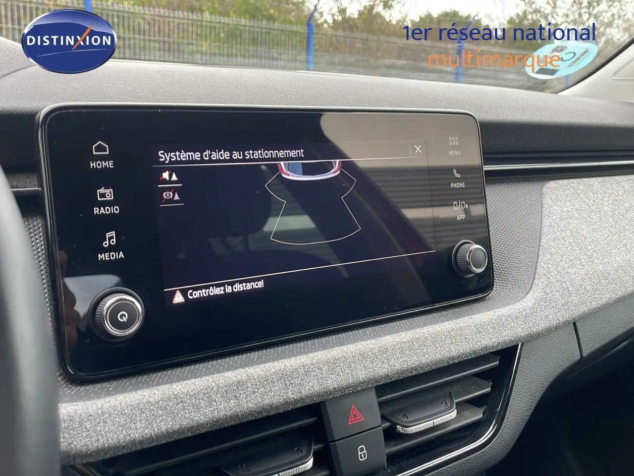 Écran tactile du système d'aide au stationnement dans l'habitacle du Skoda Kamiq rouge Velvet Metal 2024.