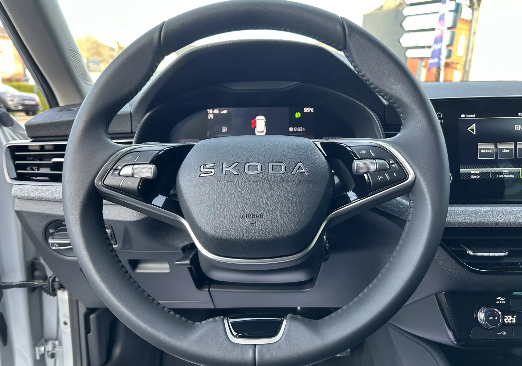 Vue rapprochée du volant cuir noir du Skoda Kamiq 2025 avec tableau de bord digital et écran central tactile.