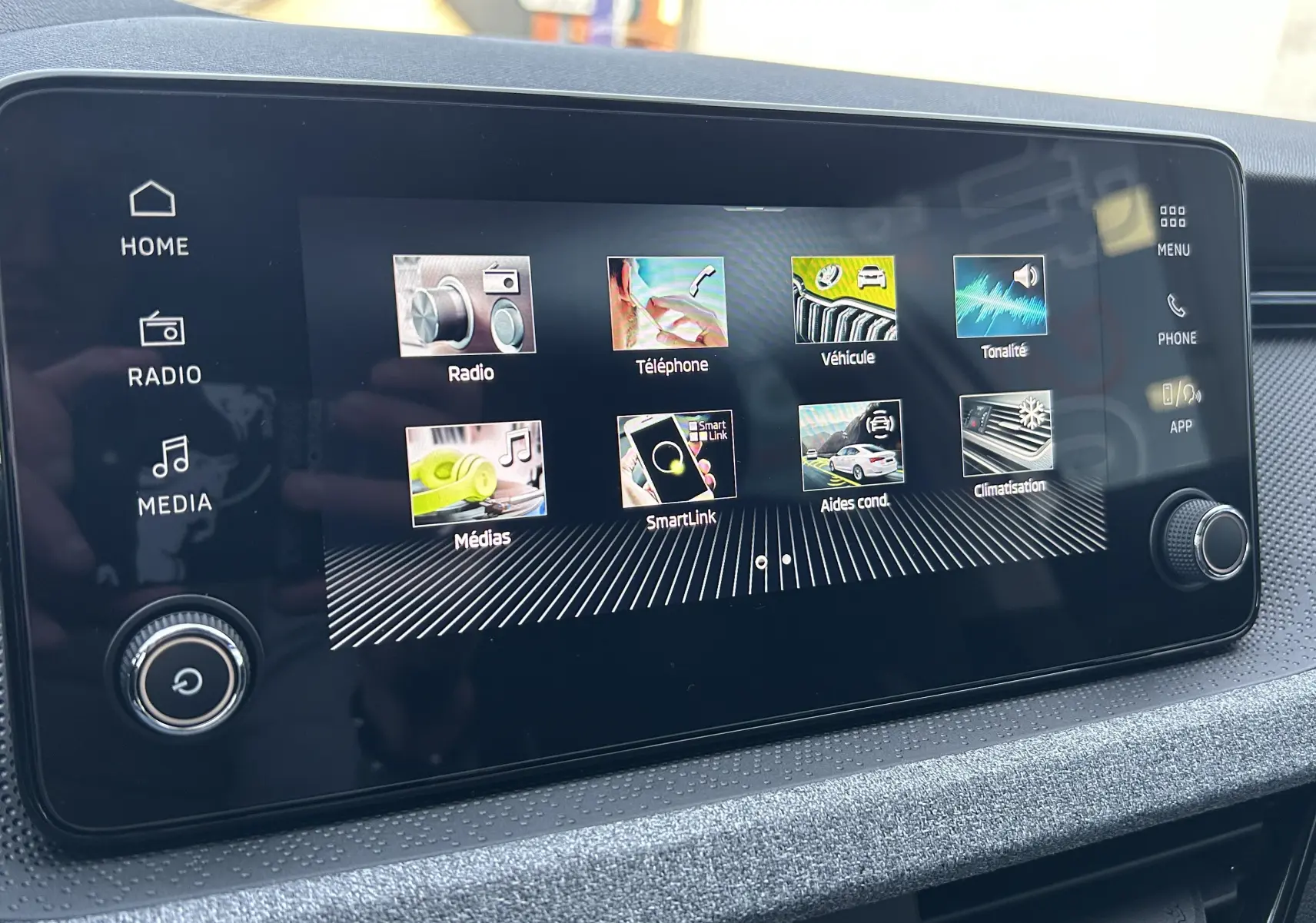 Écran tactile central du Skoda Kamiq 2025 affichant les menus radio, téléphone, véhicule, médias et climatisation.
