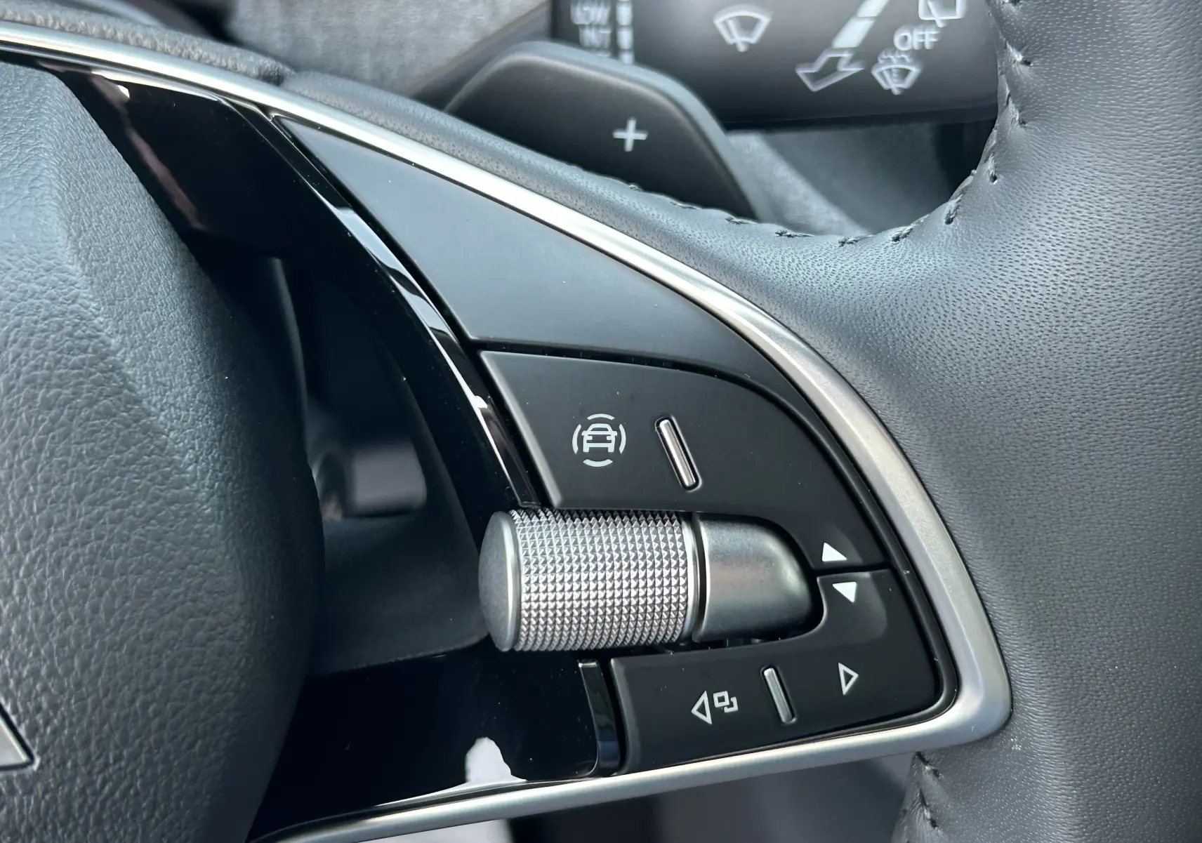 Gros plan sur les commandes de régulateur de vitesse au volant cuir gris noir d’un Skoda Kamiq 2025.