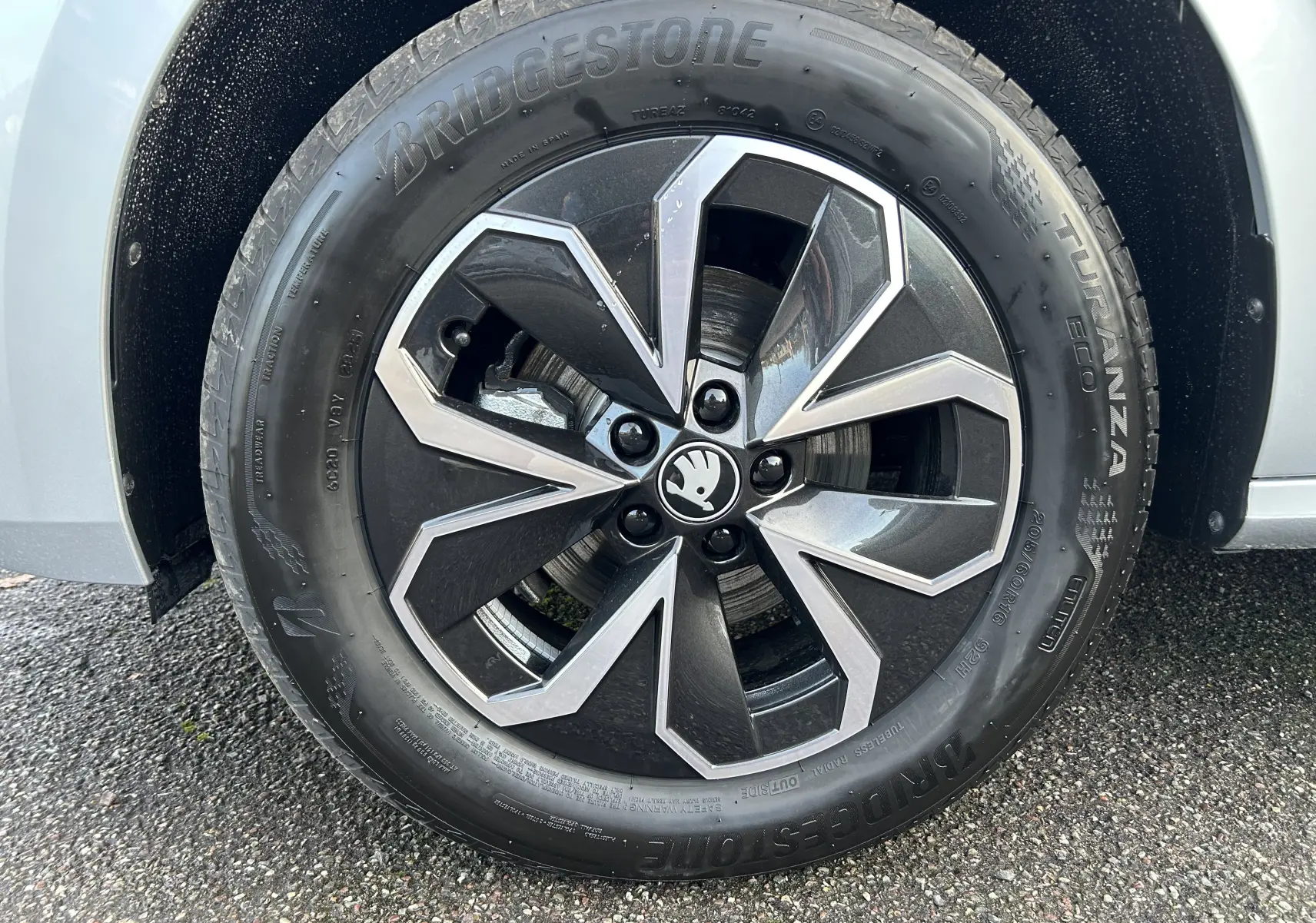 Gros plan sur la roue avant gauche gris argent du Skoda Kamiq 2025 avec jante alliage noire et argentée au design géométrique.