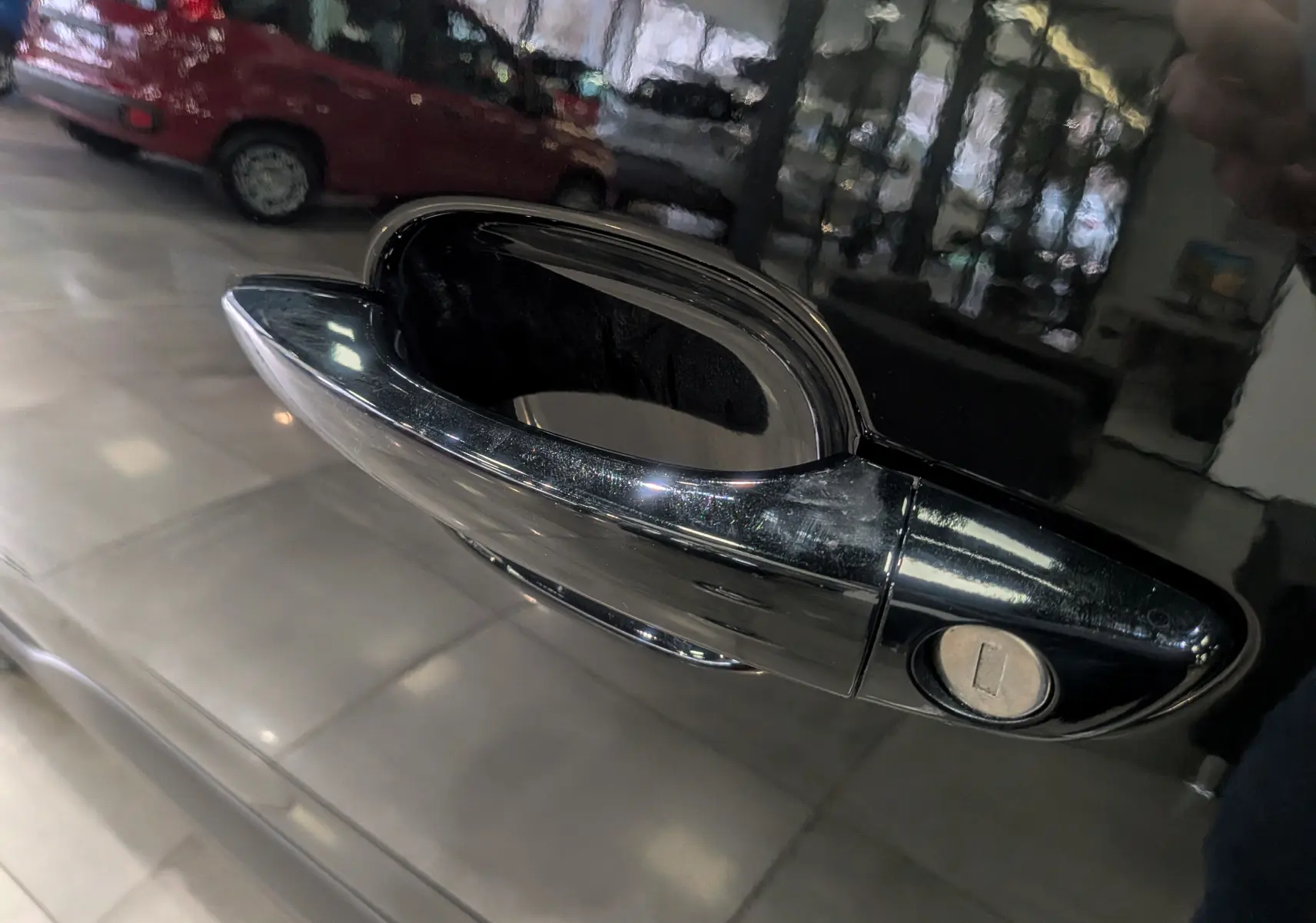 Poignée de porte noire brillante du Peugeot Rifter 2025, vue en gros plan sur le côté droit du véhicule.