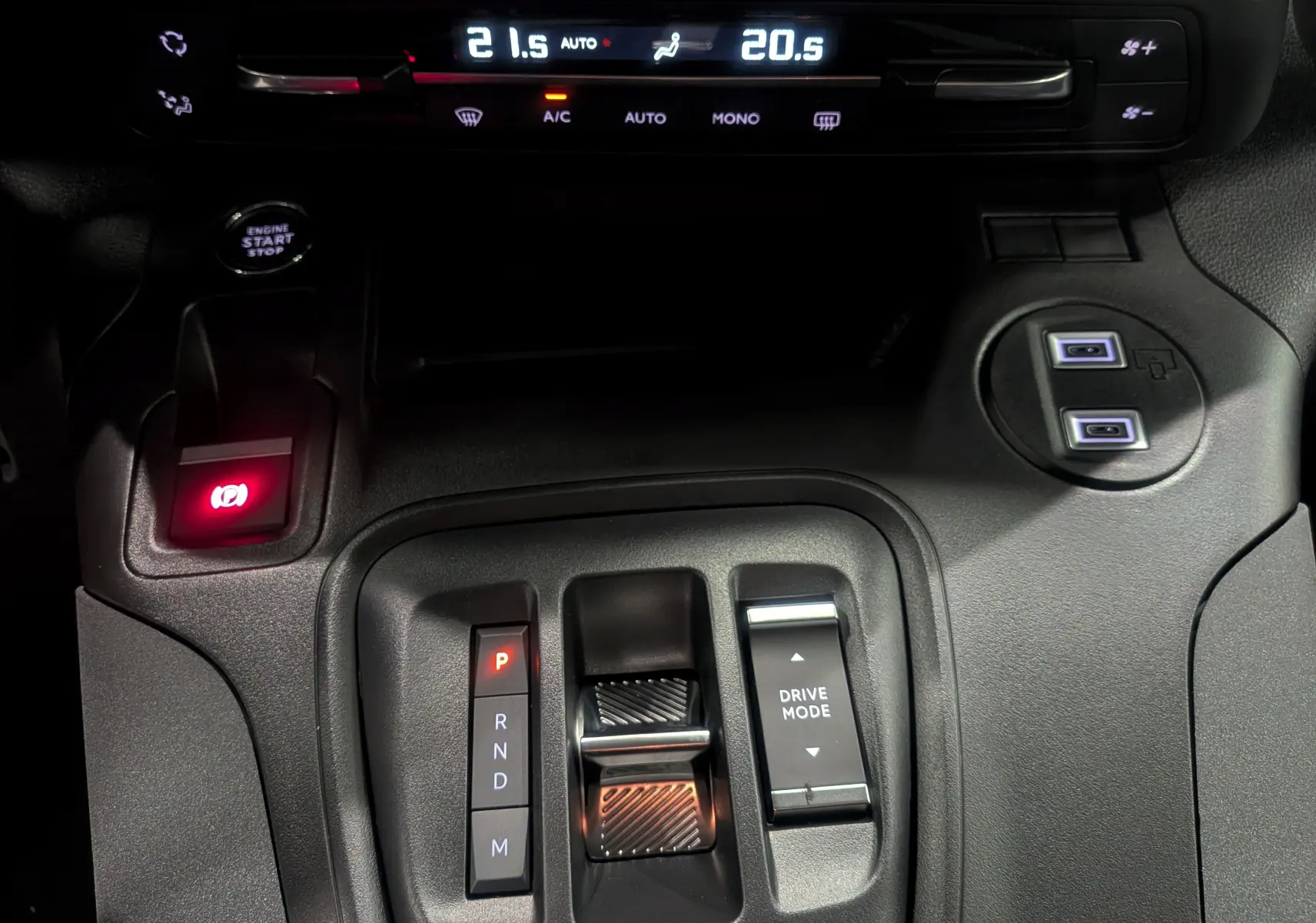 Gros plan sur la console centrale intérieure du Peugeot Rifter 2025 noir, avec levier de vitesses automatique et commandes climatisation.