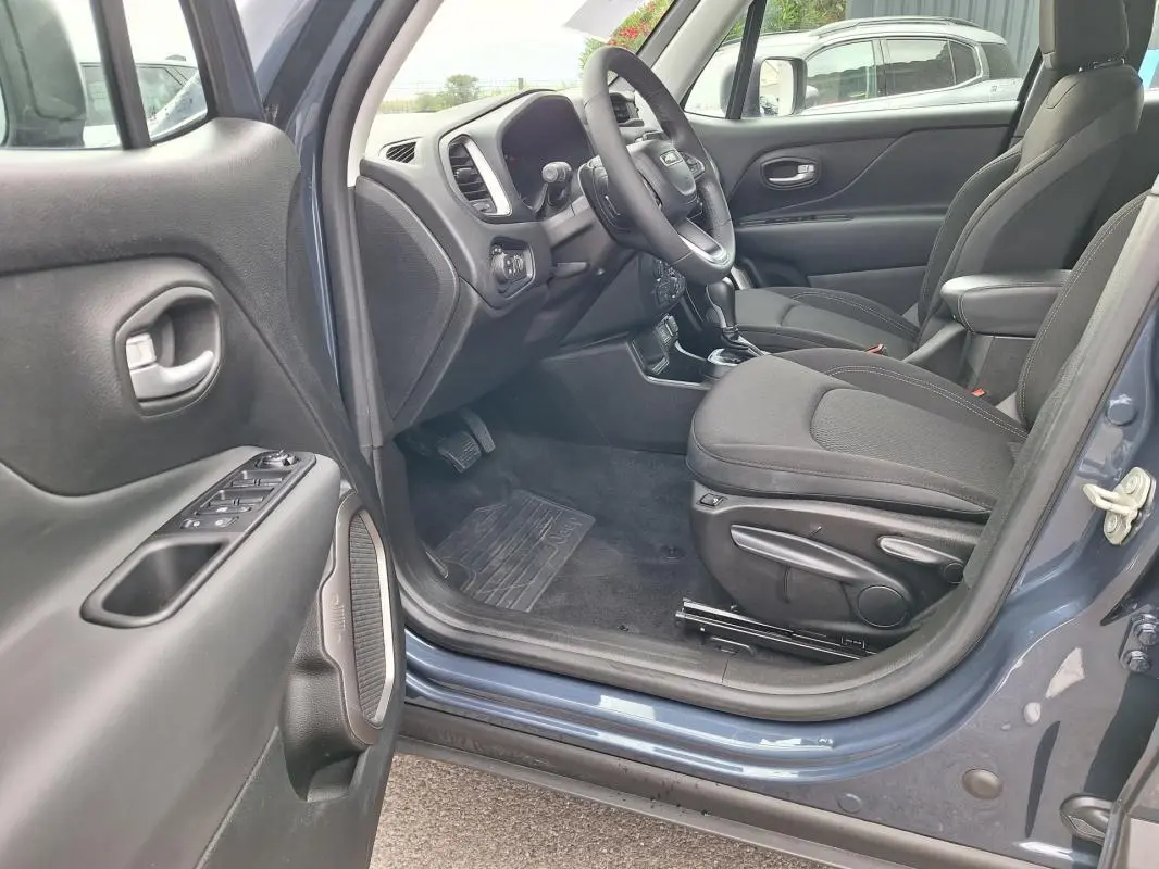 Vue intérieure côté conducteur du Jeep Renegade bleu 2024, montrant siège, volant et tableau de bord.