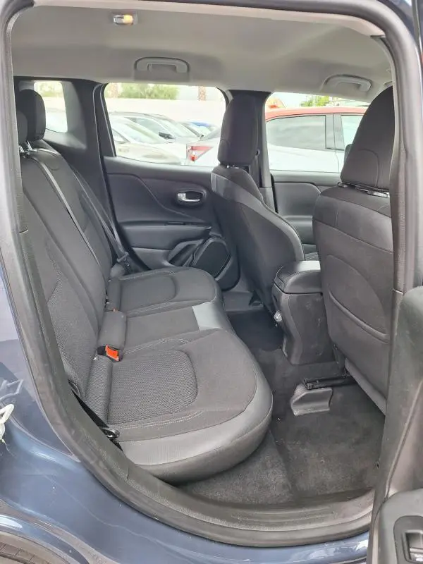Vue latérale intérieure arrière du Jeep Renegade bleu 2024, montrant les sièges en tissu noir et l'espace passager.