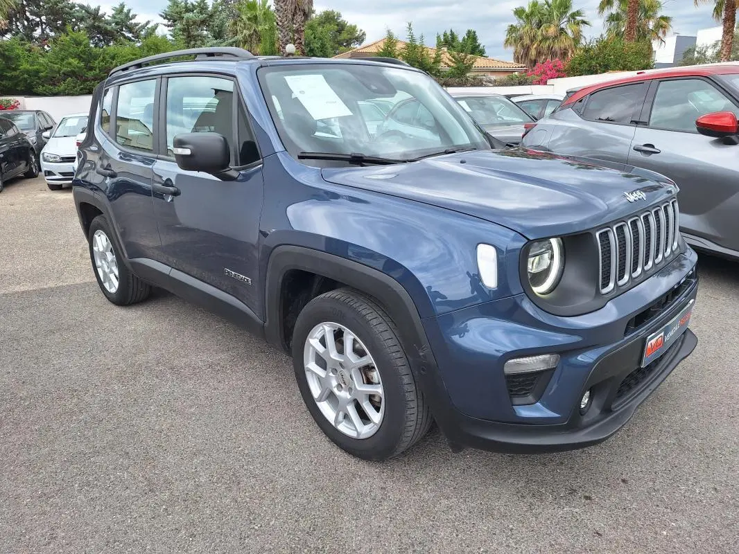 Jeep Renegade bleu vue 3/4 avant droit, avec barres de toit et jantes alliage 17 pouces visibles en extérieur.