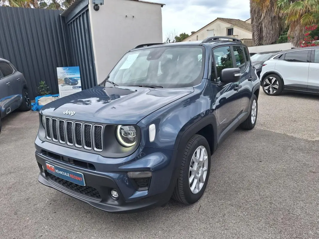 Jeep Renegade bleu vue 3/4 avant droit, avec barres de toit et jantes alliage 17 pouces visibles.