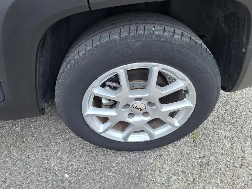 Gros plan sur la roue avant droite avec jante alliage 17 pouces du Jeep Renegade bleu 2024.